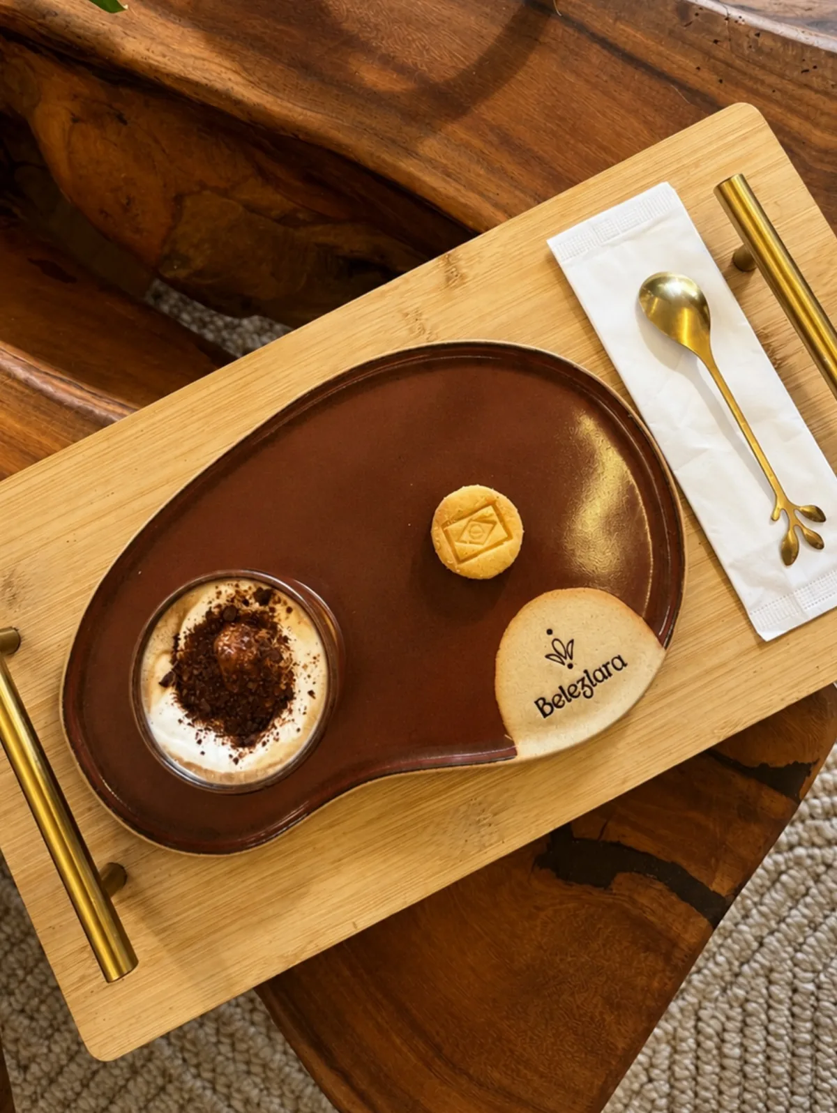 Cappuccino servido em tábua de madeira com biscoitos da marca Beleziara