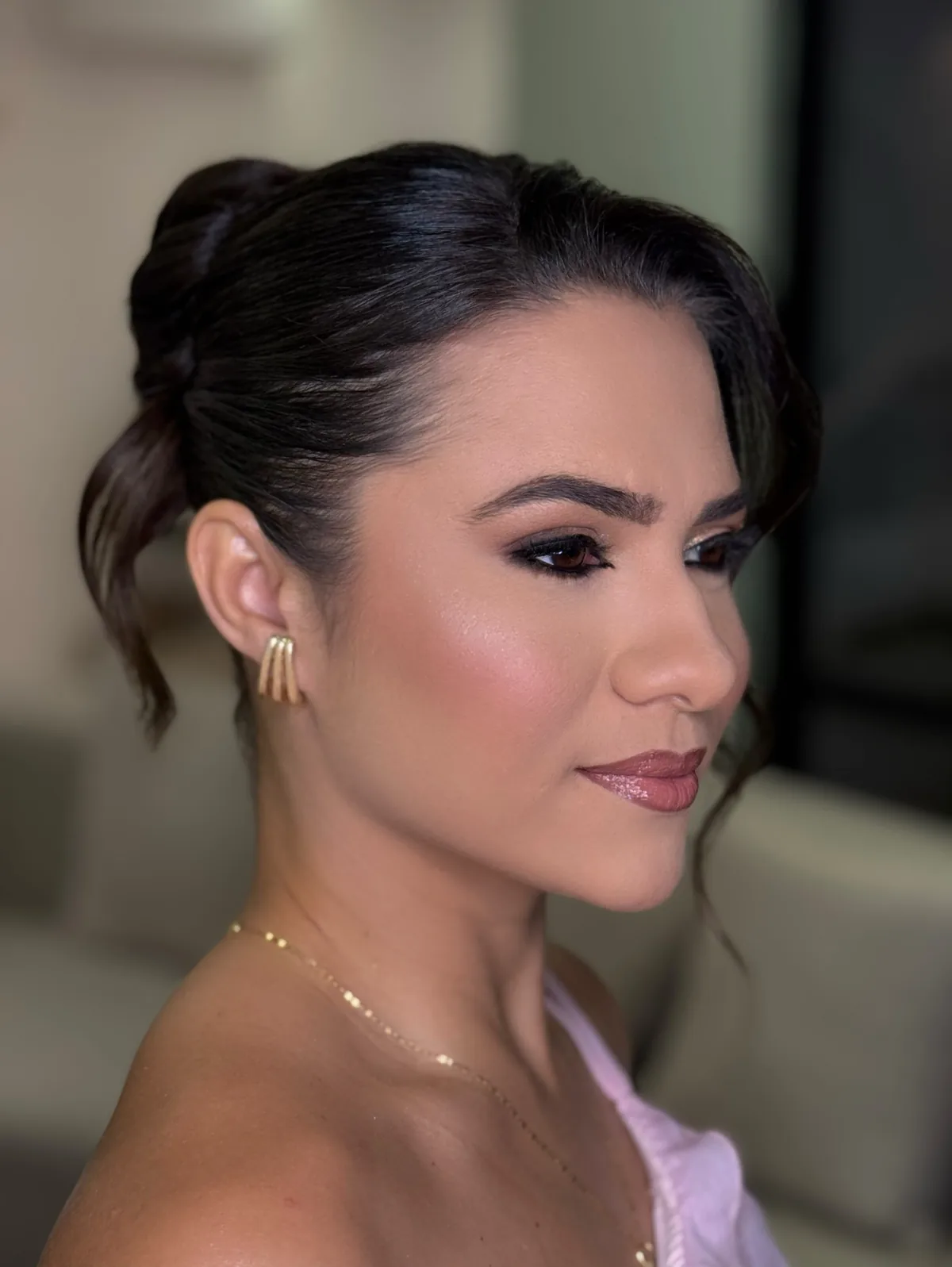 Perfil de cliente com maquiagem em tons quentes e penteado preso