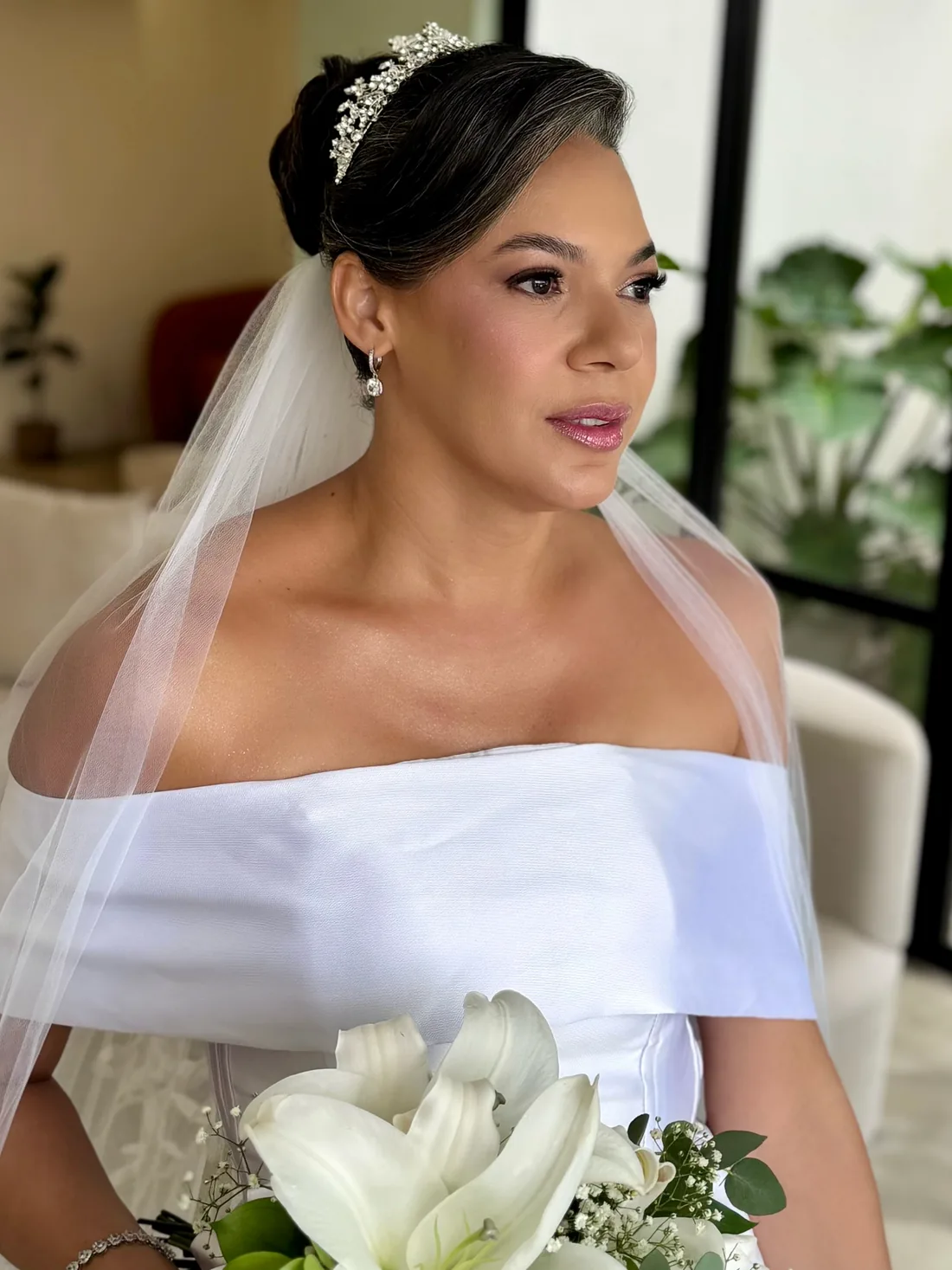 Noiva Drika com coque, tiara, véu e buquê de lírios brancos
